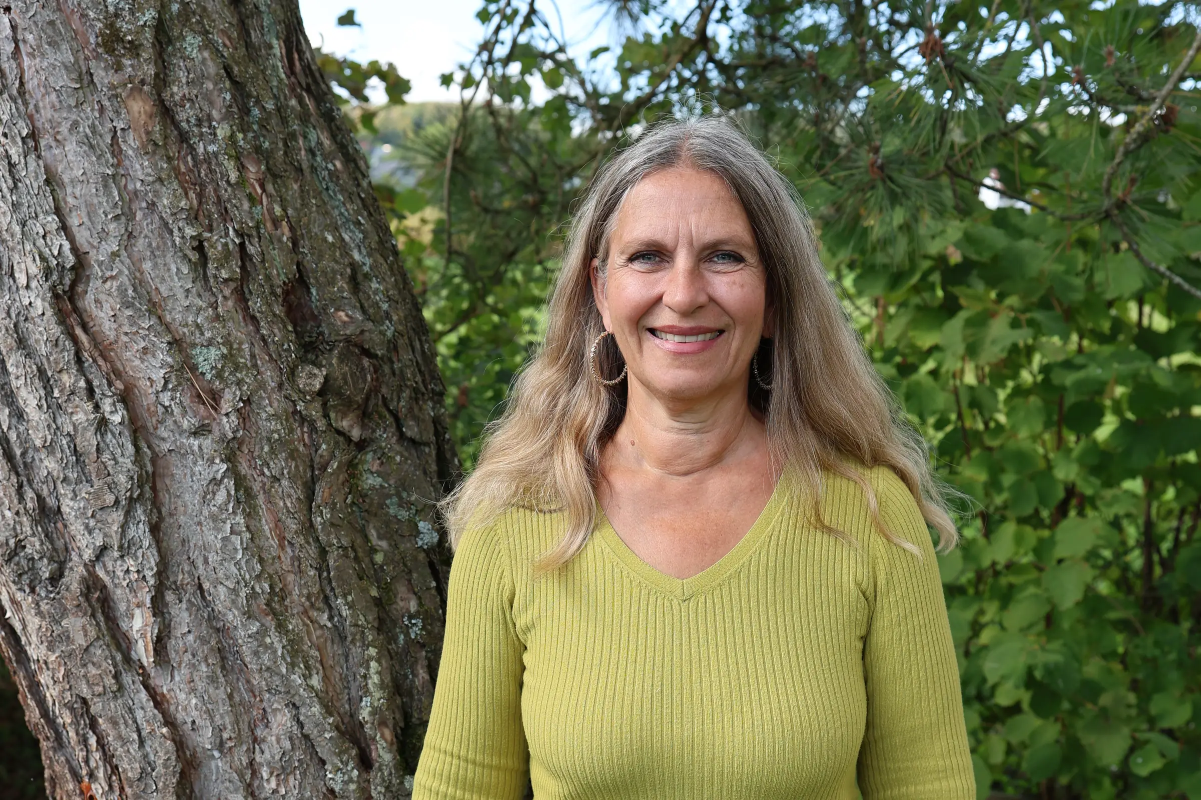 Petra Ellwanger-Schmitt, systemische Beraterin in Weßling, vor einem Baum stehend